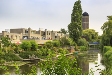 Fototapeta na wymiar Residential houses on the waterside with a water tower on the background located in Rokkeveen, Zoetermeer.