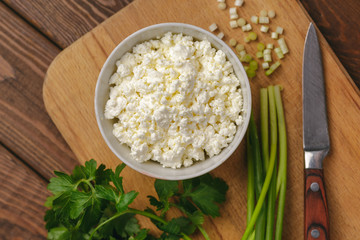 Cottage cheese in bowl for cream and fresh herb, top view. Healthy food