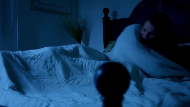 Woman awakens form a nightmare violently in her bed ALT