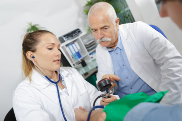 physician measuring blood pressure to make a diagnosis
