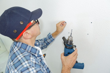 man drilling the wall with drill perforator
