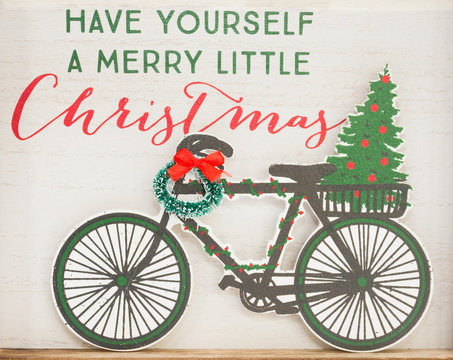 Close Up of Christmas decoration with a vintage feel showing a bicycle, wreath and the saying "Have Yourself a Merry Little Christmas".