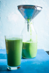 Green smothie over a blue background