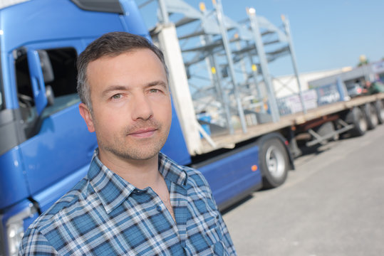 truck driver posing in front of vehicule