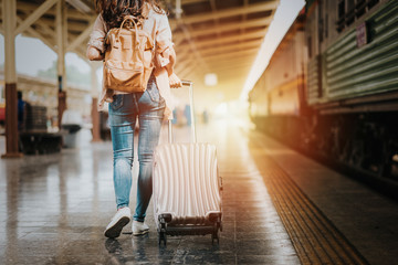 Woman traveler tourist walking with luggage at train station. Active and travel lifestyle concept