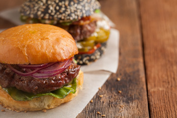 Set of three mini homemade Burger with marble beef and vegetables on a old wooden background. the concept of junk food and fast food. with copy space