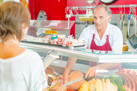 Butcher serving a customer at the deli counter