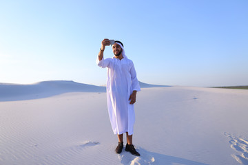 Portrait of Arabian sheikh man with gadget that communicates in 