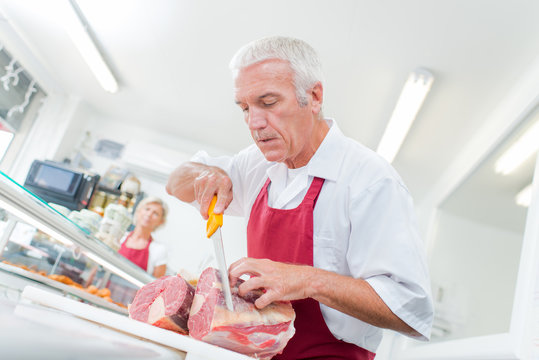 Butcher preparing cuts of meat