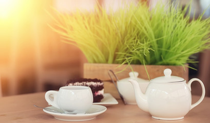 Kettle with a drink and dessert in a street cafe. Tea in the ket