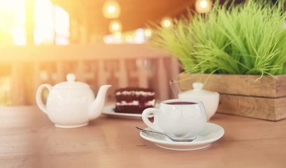 Kettle with a drink and dessert in a street cafe. Tea in the ket