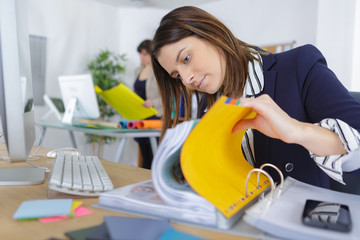 female office worker flicking through paperwork in folder