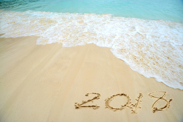 2018 written on the sand of a beach