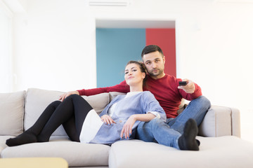 Young couple on the sofa watching television