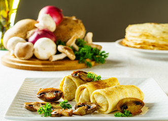 Hot Russian pancakes or blini with mushrooms.