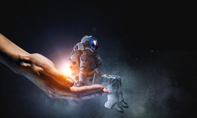 Fototapeta na wymiar Spaceman in male hand. Mixed media