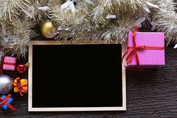 Christmas Xmas New Year holiday background with empty black chalkboard for your text and various festive decorations. blank chalkboard surrounded of christmas items top view with copy space