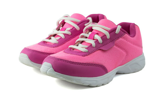 Womens pink sneakers with white laces isolated on white background.