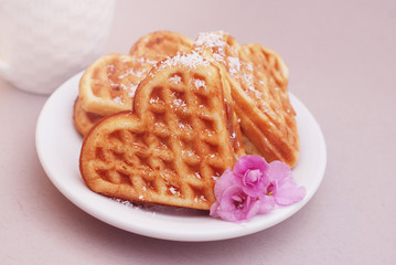 Wafer cakes in the shape of heart lie on a small plate on a served wooden table. Valentines Day Backgroud,