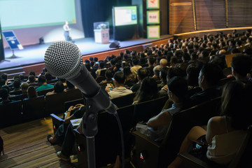Microphone with Abstract blurred photo of conference hall or meeting room with attendee background,...