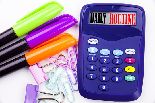 Writing word Daily Routine text in the office with surroundings such as marker, pen writing on calculator Business concept for Accuracy Procedure white background with copy space