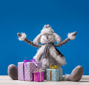  Cheerful snowman with Christmas presents in boxes sends New Year's greetings!