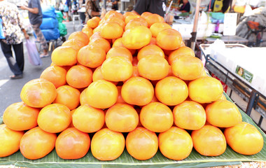 Naklejka na ściany i meble Fresh Persimmon on a cart for sell at Yaowarat market, Bangkok, Thailand