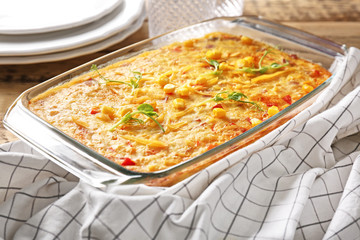 Baking dish with corn pudding on table