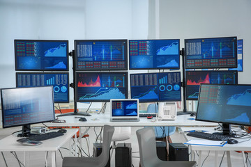 Monitors with stock data on table in office