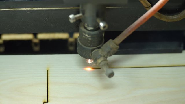 CNC machine cutting wood with a laser. CNC machine at work. Close-up.