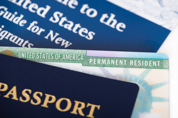 United States of America permanent resident card, green card, displayed with a passport. Immigration concept.