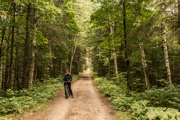 Girl with bicycle biking Canada Ontario Lake of two rivers natural wild landscape in Algonquin National Park
