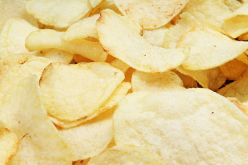 Chips pattern. Yellow salted potato chips as background. Chips texture studio food photo.