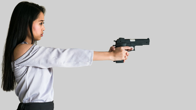 An Asian woman is aiming handgun to a target in front of her