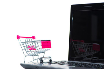 Shopping cart or supermarket trolley with laptop notebook isolated on white background, e-commerce and online shopping concept.