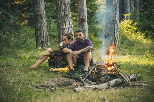 Couple in love relax at campfire in wood