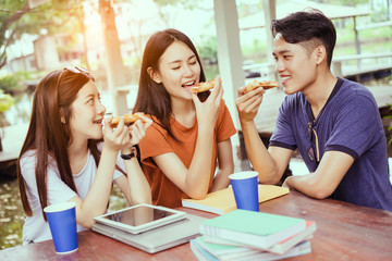 Students asian group together eating pizza in breaking time early next study class having fun and enjoy party italian food slice with cheese delicious at university outdoor