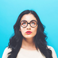 Fototapeta premium Young woman looking upward on a solid background
