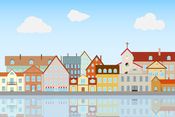 Fototapeta premium Street of the old city, embankment. Houses are reflected in the water.