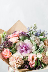 beautiful bouquet of mixed flowers into a vase on wooden table. copy space
