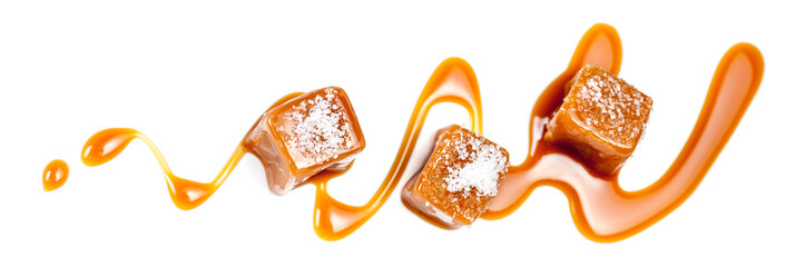 Homemade salted caramel pieces isolated on white background. Golden Butterscotch toffee candy caramels macro. - obrazy, fototapety, plakaty