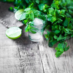 Fresh Mojito cocktail on a rustic table close up, selective focus.