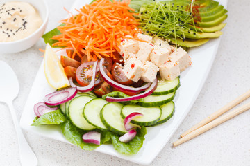 Vegan lunch salad with tofu, hummus and vegetables.