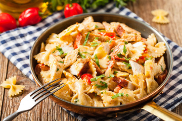 Pasta farfalle with chicken and paprika, in carbonara sauce.