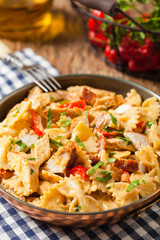 Pasta farfalle with chicken and paprika, in carbonara sauce.