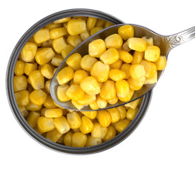 Pile of a canned corn and a spoon over it, composition isolated