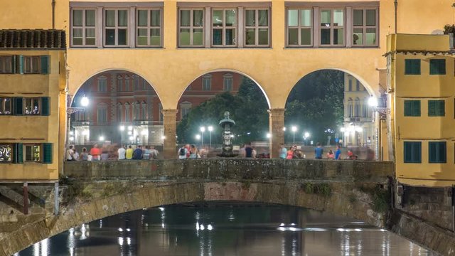 Famous Ponte Vecchio bridge timelapse over the Arno river in Florence, Italy, lit up at night
