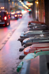 Abfalltonnen am Straßenrand, Abend und unscharfe Autos/Stau