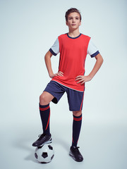 Photo of teen boy in sportswear holding soccer ball