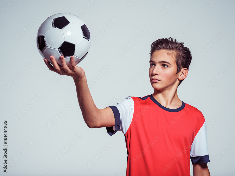 Wall mural photo of teen boy in sportswear holding soccer ball